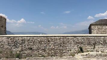 fästning i gjirokastra en enorm sten byggnad på en hög berg i albania med en klocka de historia av de mitten åldrar en skön se från de sten stad till de gammal by video