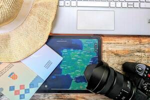 Passport, tablet, laptop and world map on wooden table, travel and adventure concept, background, copy space area photo