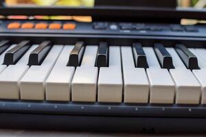 de cerca de piano llaves. piano negro y blanco llaves y piano teclado musical instrumento metido a el hogar balcón durante soleado día. foto