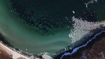 von oben nach unten Drohne Aussicht von das Küste mit Klippen, klar Meer, schwebend Eis Schollen video