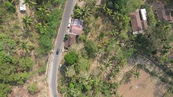 antenne visie van kronkelend weg in Yogyakarta onderdistrict, centraal Java wijk is behandeld naar een heuvelachtig landschap video