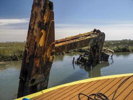 abandoned rusted bulldozer in Aveiro lagoon Ria de Aveiro located on the Atlantic coast of Portugal photo