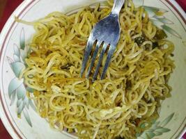 un plato con tallarines y un tenedor foto