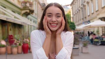 jovem feliz caucasiano mulher desfrutando sorridente cheio de dentes dental sorrir Diversão alegre satisfeito fêmea olhando às Câmera satisfeito modelo alegre menina cidade rua lado de fora gesto comemoro Boa humor urbano sucesso video