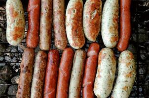 Set of grilled sausages cooked on barbecue grill detailed photo