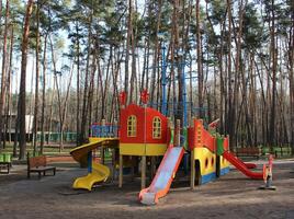 Empty open air colored play park with straight and spiral slides for children photo