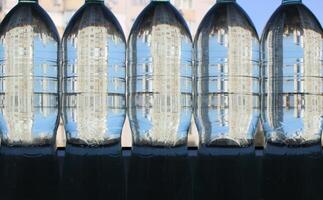 Skyscrapers reflected in bottles filled with purified water photo