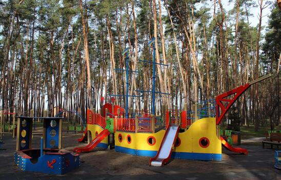 Sandbox, multi-colored slides and swings on the playground for active games in the green area photo