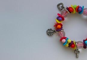 Concept For Postcard Of Wallpaper With Colorful Beads And Silver Charms Bracelet In A Side Of Image photo