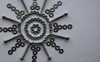 Concept For Steel Art Design. Steel Hardware Items Laid Out In Flower Pattern On White Surface At A side Of Image photo