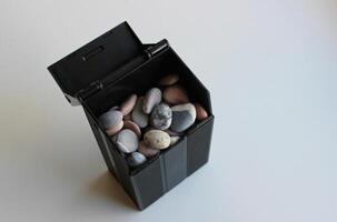 negro envase Bosquejo lleno con de colores guijarros en blanco valores foto a ilustrar el tema de construcción