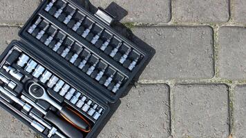 Steel Mechanics Tools In Separate Slots In Special Plastic Box On Concrete Floor photo