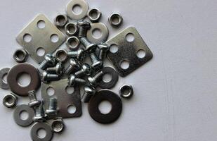 Bunch of assorted washers, spacers, nuts and bolts on the scratched surface of a workbench. Stock Photo For Metal Hardware Illustration