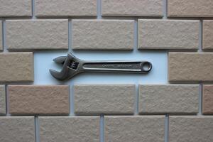 Adjustable Wrench In Compartment Inside Tiles Brickwork Top View. Stock Photo For DIY Repair Illustration