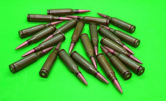 Live ammunition with red mark on a bullets studio isolated on a green surface photo