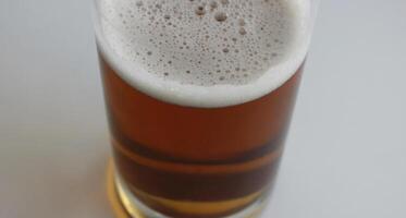 Rich color of semi-dark draught beer in a mug on white background top view photo