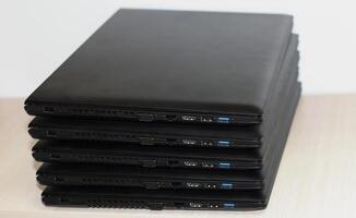 Stacked black notebook computers detailed stock photo