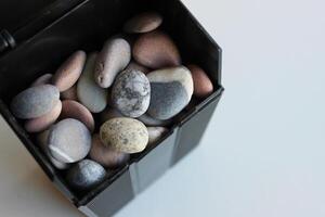 Model Of Black Can With Round River Rocks Closeup Top View photo