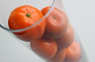 Glass With Ripe Mandarins Isolated On White Top View photo