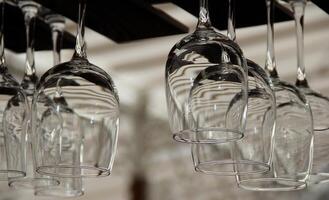 Clear wine glasses hanging at bar counter on city street stock image photo