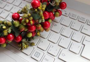 Artificial Decor Made Of Colored Berries And Textile Leaves On White Keyboard With Latin Characters Only photo