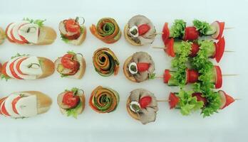 Set of appetizer table settings on the shelves on white tablecloth photo