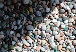 A pattern of sea pebbles separated by the sun's rays into illuminated and shadow zones photo