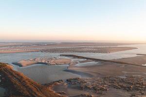 New fertile land and housing for new Dutch residents on Plaat van Walsoorden in the southern region of the Netherlands. Sunrise illuminates the drying areas photo