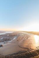 Drying shore at low tide of Plaat van Walsoorden at Ossenisse radar in the southern Netherlands under the brilliant orange-yellow glow of sunrise photo