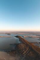 Drying shore at low tide of Plaat van Walsoorden at Ossenisse radar in the southern Netherlands under the brilliant orange-yellow glow of sunrise photo