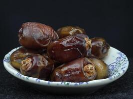 A Small Serving of Dates Arranged Elegantly on a Plate photo