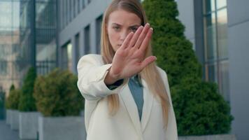 Serious displeased angry Caucasian woman girl businesswoman business lady showing stop gesture palm hand outdoors reject offer prohibit show refusal prohibition warning sign shake finger deny forbid video