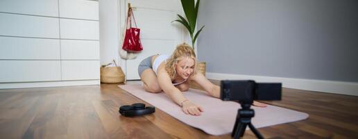 Young athletic woman trainer practicing Hatha Yoga, instructor personal training Vasisthasana, balancing pose, workout at home. Concept of healthy lifestyle and wellbeing photo