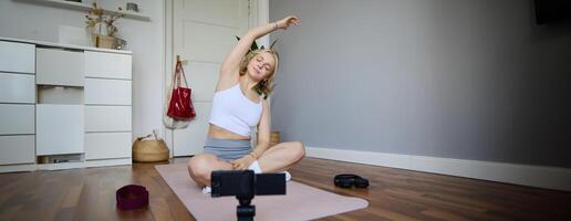 Young athletic woman trainer practicing Hatha Yoga, instructor personal training Vasisthasana, balancing pose, workout at home. Concept of healthy lifestyle and wellbeing photo