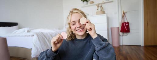 cerca arriba retrato de feliz, hermosa joven vloguero, contenido fabricante grabación acerca de constituir, demostración belleza productos en cámara, sonriente felizmente foto