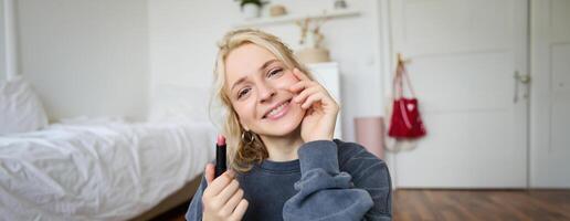 Portrait of young beautiful woman recording blog in her room, lifestyle beauty content for social media, talking in front of camera, live stream chatting online with followers photo