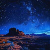 Stars trailing in the night sky over a silent desert photo