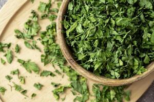 Wooden bowl with green dry parsley. Vegetarian bio organic salad herb healthy eating. Home garden immunity-boosting herbs. Seasonal harvest cottagecore photo