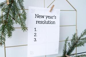 NEW YEAR'S RESOLUTION paper note on Dream board promises and aims. Preparation for new year new life new me. Visualizing wish list for 2025. Dreams plan action for coming year. Inspirational self improvement concept photo