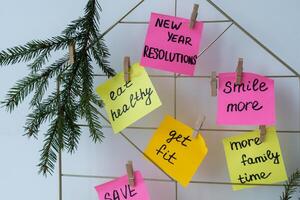 acción tablero nuevo años resoluciones en vistoso pegajoso notas haciendo promesas para nuevo año, ajuste objetivos. sueño año motivación foto