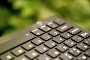 cerca arriba foto de teclado con verde hojas antecedentes