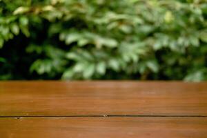 Selective Focus and Blur on Wooden Table with Green Leaves as Commercial Background photo