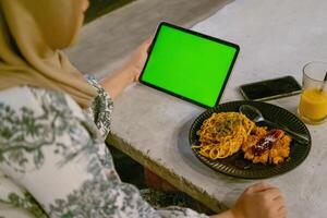 Green Screen iPad or Tablet with Cafe Ambiance and Food on Table photo