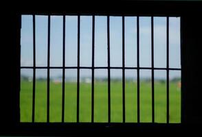 The prisons iron bars with a refreshing view beyond photo