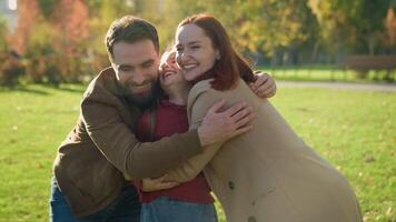 content caucasien famille en riant étreindre ensemble vacances fin de semaine à ensoleillé ville l'automne parc Parents peu enfant enfant fille fille étreinte rire sourire Assurance collage garde câlins en bonne santé gens Jeu video