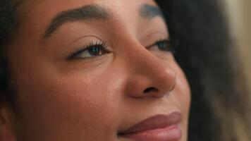 Close up pretty face African American ethnic woman young peaceful girl beautiful female looking up eyes purity meditating contemplating dreaming look in window smile natural beauty makeup health care video