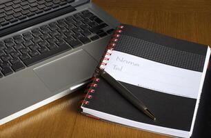 Phone, laptop and empty notebook on the desk photo