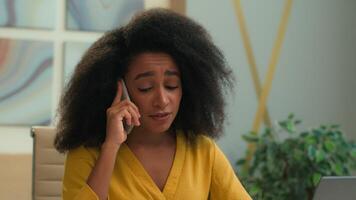 descontente Bravo louco africano americano étnico fêmea Empregador Gerente menina senhora empresária discutindo conversa Móvel telefone estressado irritado furioso o negócio mulher brigar gritar Smartphone ligar dentro escritório video