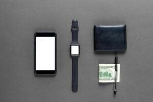 Business concept. Top view of dollars, watch, smartphone on color background photo