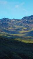 hillside overgrown with dry grass against the backdrop of snow-capped mountains video